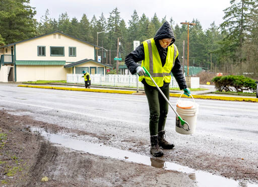 Phyllis Becker of Port Hadlock, foreground, and Wendy Davis of Port Townsend, volunteers with the Jefferson County Trash Task Force, pick up litter along Discovery Road on Sunday during the first trash pickup of the year. (Steve Mullensky/for Peninsula Daily News)