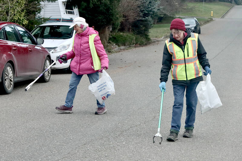 Dona Cloud and Kathy Estes, who call themselves the “Garbage Grannies,” volunteer each Wednesday to pick up trash near their neighborhood on the west side of Port Angeles. They have been friends for years and said they have been doing their part to keep the city clean for five years now. (Dave Logan/for Peninsula Daily News)