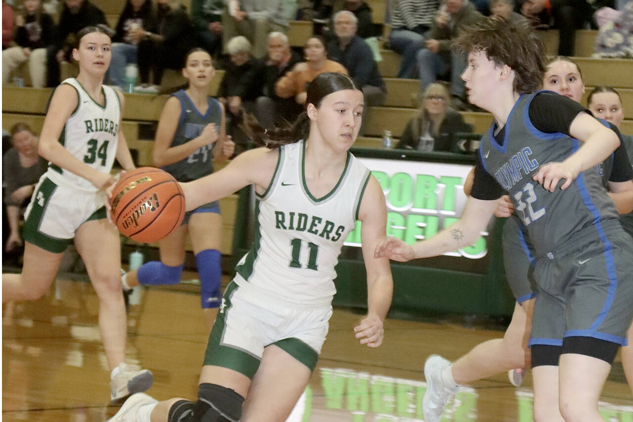 Dave Logan/for Peninsula Daily News
Port Angeles' Lindsay Smith drives to the basket and tries to get past Olympic’s Gabi McCoy during the Roughriders' win over the Trojans on Friday. In the background is Lexie Smith (34)