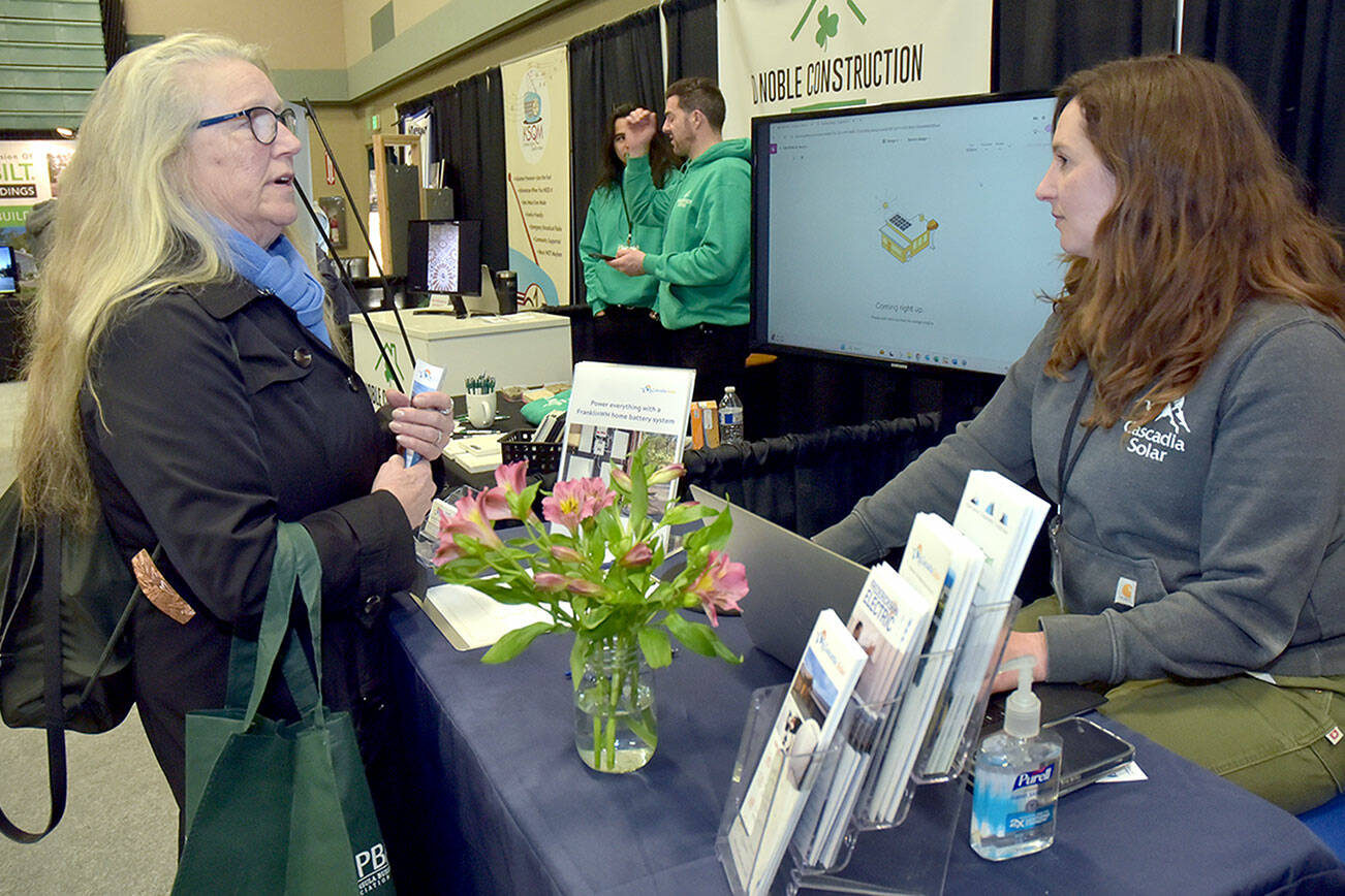 Cheryl Gertsch of Sequim, left, talks with Krista Meyers, project manager with Cascadia Solar of Port Townsend during the annual Home Building, Remodeling and Energy Expo on Saturday at Sequim Middle School. The event, hosted by the North Peninsula Building Association, featured a variety of booths, displays and presentations dedicated to home construction, repair and improvement. (Keith Thorpe/Peninsula Daily News)