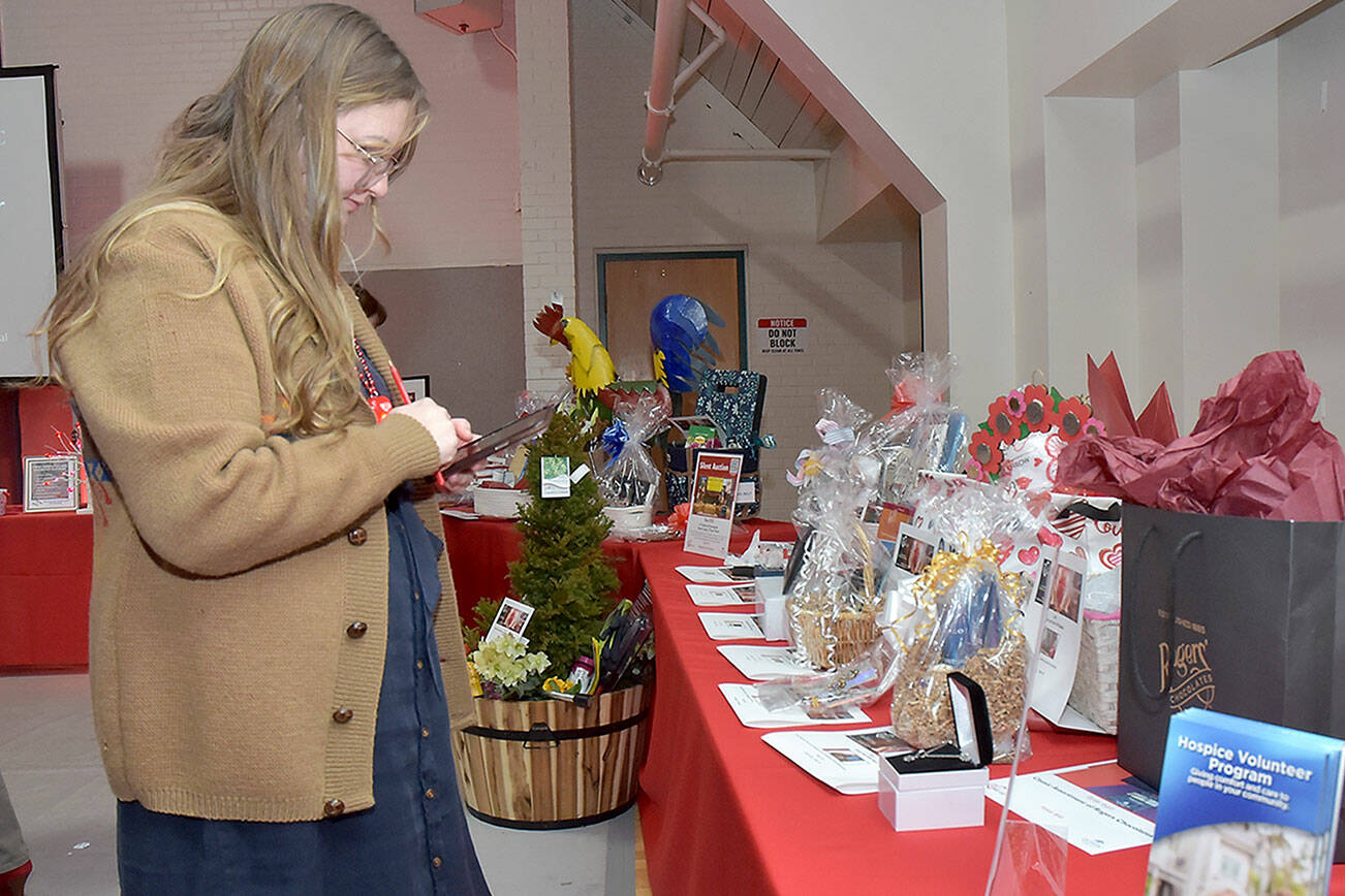 Sonja Elofson of Port Angeles examines a table of auction items during Friday’s “Red, Set Go!” heart healthy luncheon at Vern Burton Community Center in Port Angeles. The event, hosted by the Olympic Medical Center Foundation and presented by Virginia Mason Franciscan Health, was designed to raise funds for the Olympic Medical Center Heart Center. (Keith Thorpe/Peninsula Daily News)