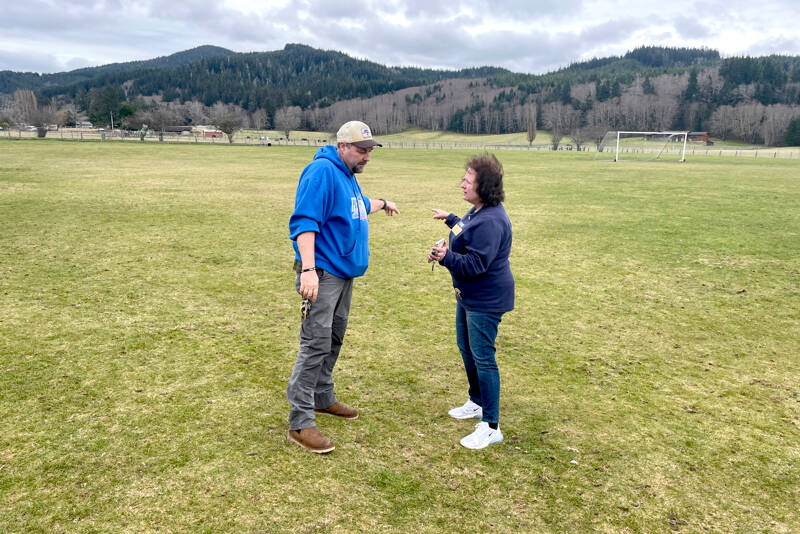 Quillayute Valley School District maintenance and facilities manager Bill Henderson, left, and Superintendent Diana Reaume check out the site on campus where new softball and baseball fields will be constructed. The $3 million project is scheduled to open sometime in 2026. (Paula Hunt/Peninsula Daily News)